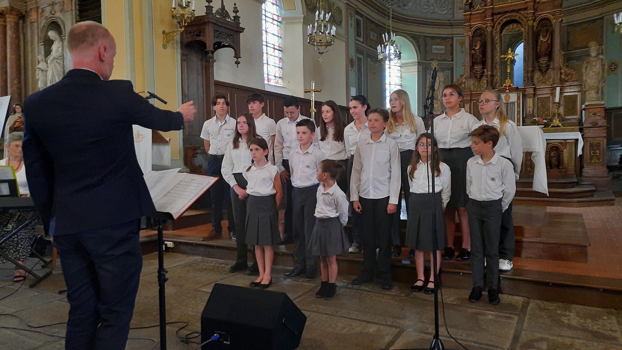 chorale des chanteurs enfants en tenue dans l'église et un chef d'orchestre de Combourg