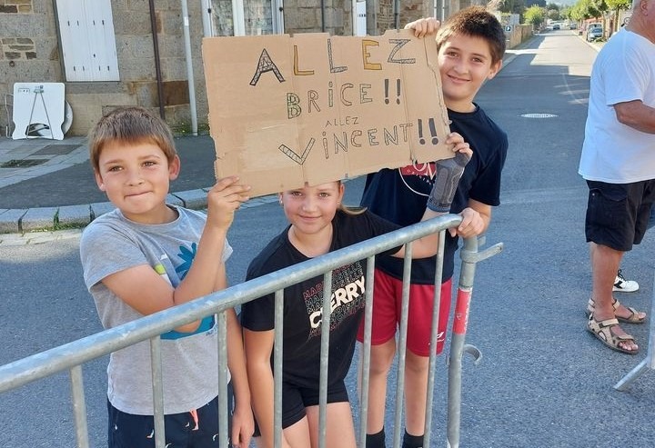 Trois enfants tiennent une pancarte d'encouragement
